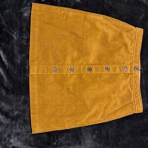 Jcrew, a line, above the knee, dark mustard colored skirt with pockets.